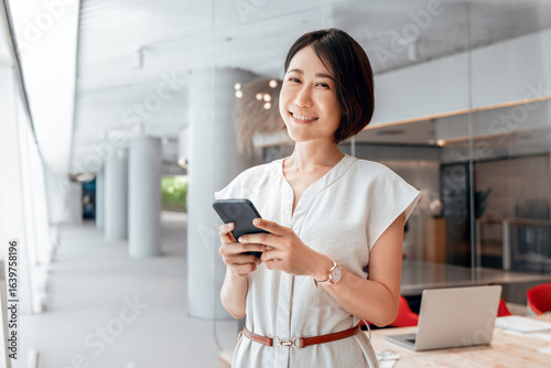 Fotografie Asian mature business woman manager ceo using cell phone mobile app