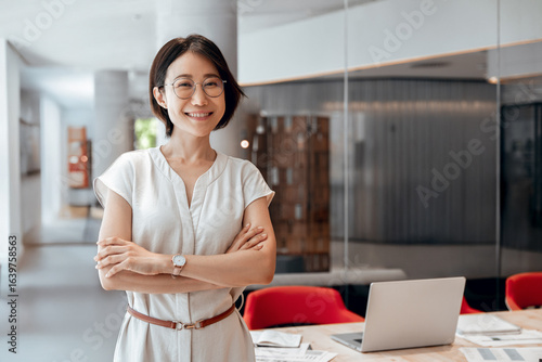 Fotografie Portrait of beautiful Asian young business sale woman with crossed arms smiling at camera