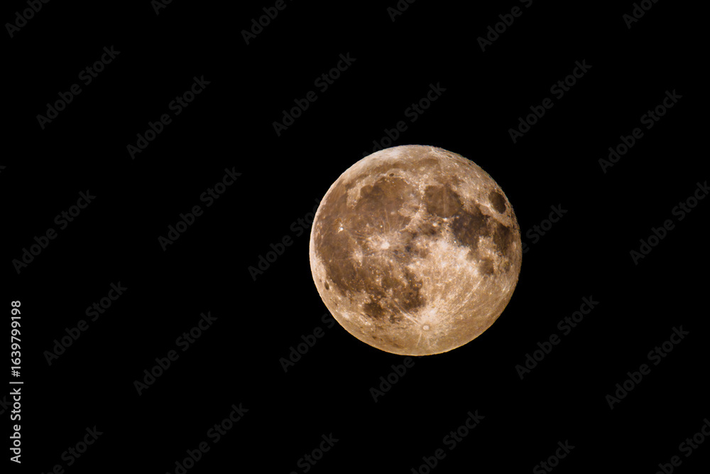 Fototapeta premium Full Moon (Luna) with detailed craters and warm surface tones in black sky