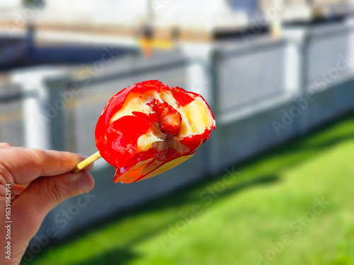 close-up photo of hand holding open Brazilian strawberry of love candy - morango do amor
