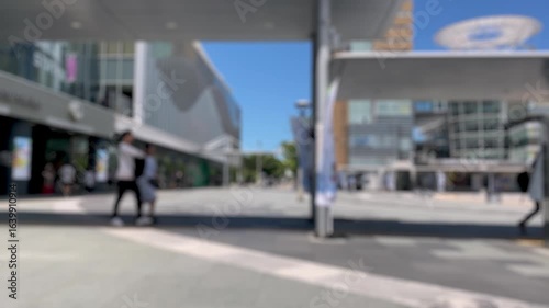 夏の駅前広場と歩く人々（手持ち）