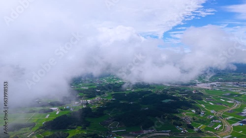 Aerial Drone View of Highway and Cars Driving Through Green Fields and Forest, with Vast Summer Landscape, Blue Sky, and Clouds for a Healing Scenery