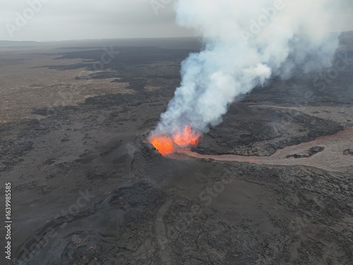 4K Aerial Drone Footage of an Active Volcanic Eruption with Lava Flow and Smoke over a Rugged Lava Field