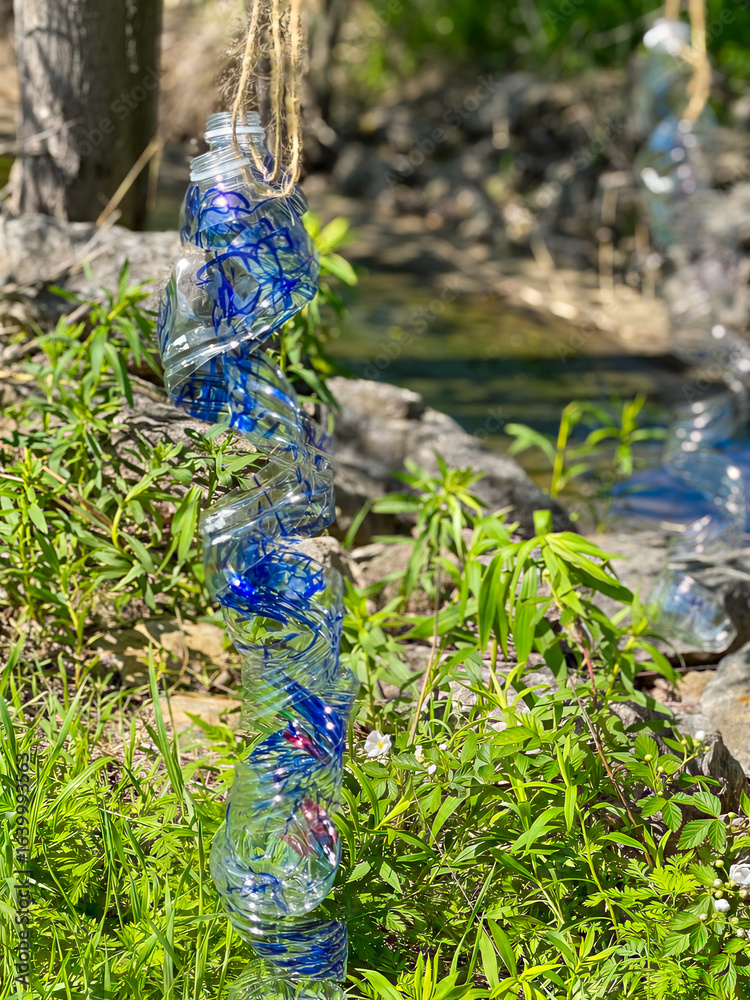 Obraz premium Twisted Plastic Bottle Hanging as Eco-Friendly Garden Decoration