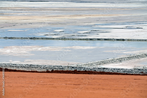 Person standing on sludge plain at tailings dam in gold mine
