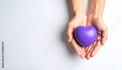 Person holding a purple heart-shaped object in cupped hands, symbolizing care and love.