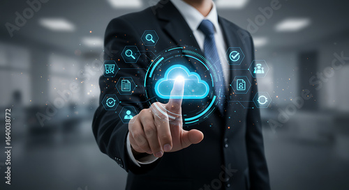 A businessman in a suit touches a digital cloud icon surrounded by application icons, representing cloud computing technology and online services for business