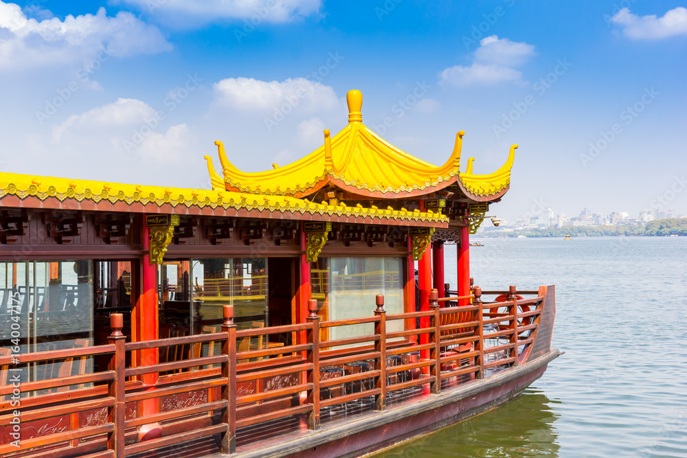 Fototapeta premium Tourist cruise boat in traditional chinese style on the West lake in Hangzhou, China