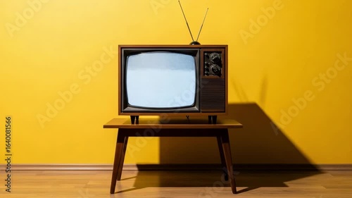 Retro Vintage TV on a Wooden Table Against a Bright Yellow Wall