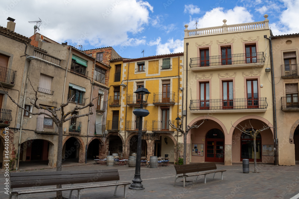 Fototapeta premium Main square of Prades, a charming village in Baix Camp, Tarragona, Catalonia, Spain, known as the “Red Town” for its distinctive reddish sandstone buildings.