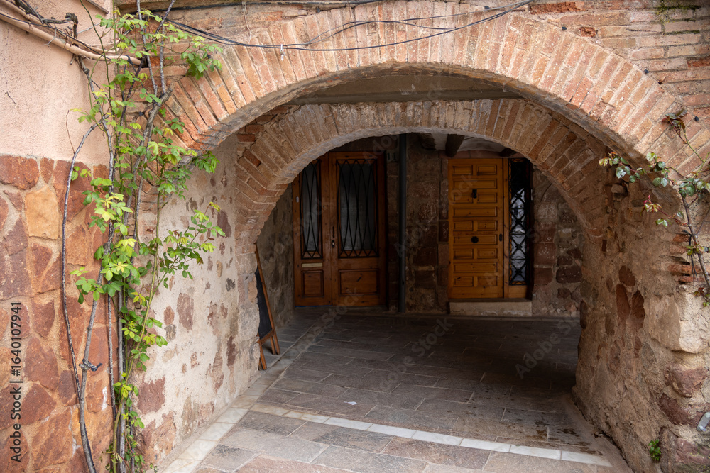 Fototapeta premium Main square of Prades, a charming village in Baix Camp, Tarragona, Catalonia, Spain, known as the “Red Town” for its distinctive reddish sandstone buildings.