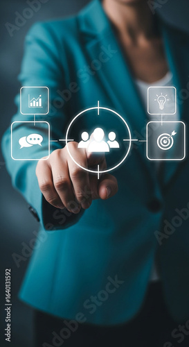 Photo of a business woman is pointing to a target audience icon with business strategy icons around it, representing business goals