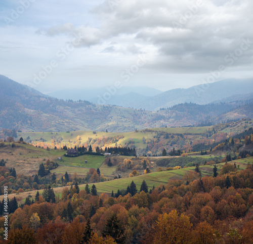 Cloudy and foggy day autumn mountains scene. Peaceful picturesque traveling, seasonal, nature and countryside beauty concept scene. Carpathian Mountains, Ukraine.