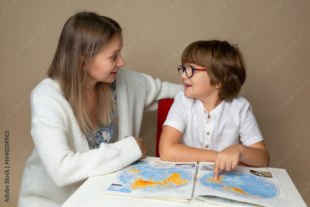 Mother and son looking at a map together, learning about geography Mother and son looking at a map together, learning about geography