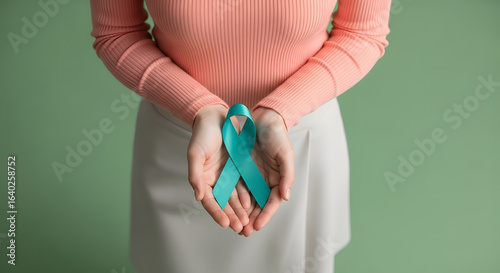 Ovarian and Cervical Cancer Awareness. Woman Holding Teal Ribbon on Lower Abdomen, Uterus, Female Reproductive System, Women's Health, PCOS and Gynecology