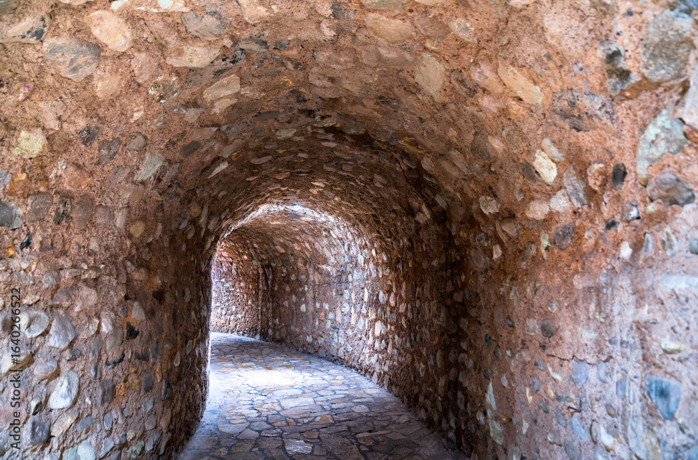 Fototapeta premium Curving stone tunnel with an arched ceiling and paved floor, leading to the Museum of Maya Sculpture at the Copan archaeological site in Honduras