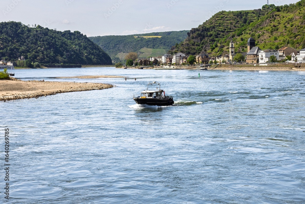 Obraz premium Scenic Rhine River view with boat and village.