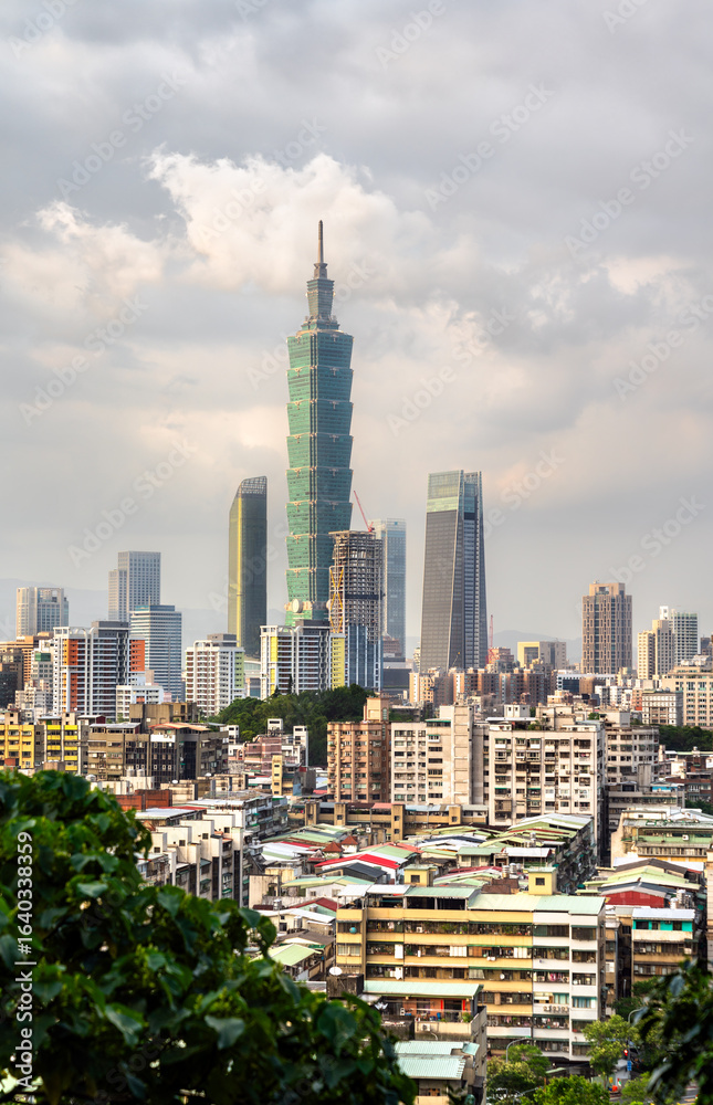 Obraz premium An elevated view of the Taipei city skyline, featuring the famous Taipei 101 tower and surrounding urban landscape against a cloudy sky in Taiwan