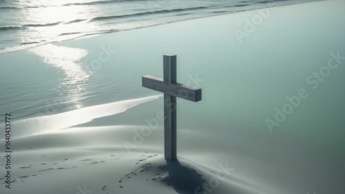 Wooden cross on tranquil beach at sunrise