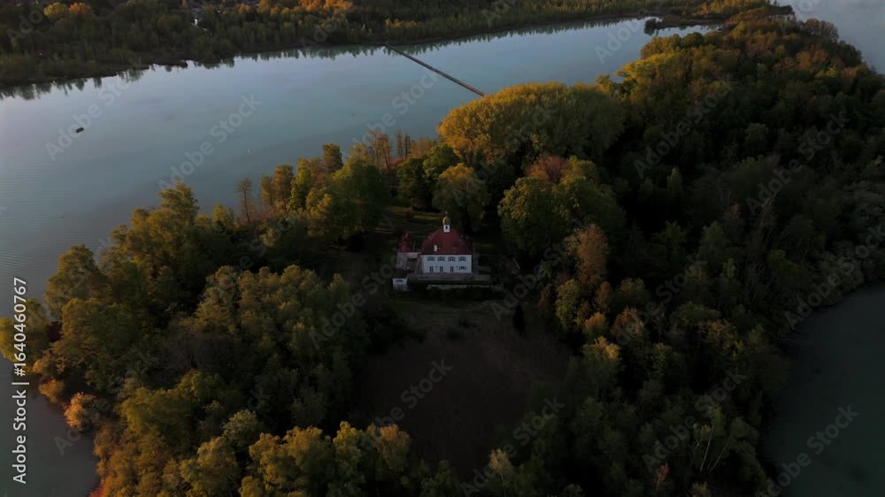 Aerial view Mausinsel, Mouse Island in Woerthsee, Bavaria, Germany. Features Castle Woerth and St. Simpert Chapel, surrounded by water and nature during peaceful sunset scene. Luftbildansicht Worthsee