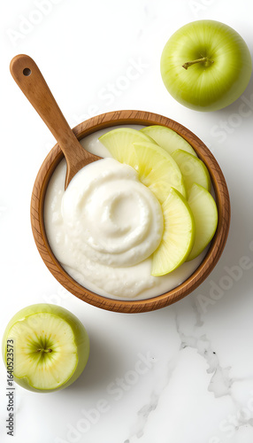 Yogurt in a wooden cup with green apple.