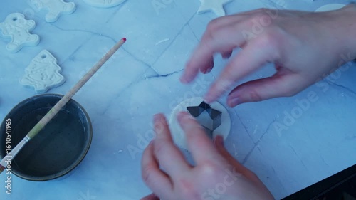 Creator is using white air dry clay for making decor to Christmas tree holiday. Creating hobby recreation activity that involves fingers. DIY crafting Modern art 