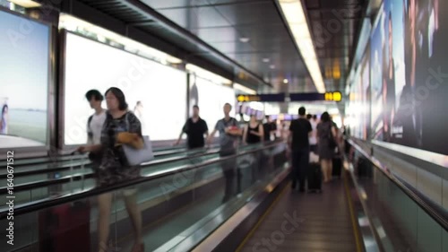 People traveling on moving walkway in modern building blurred motion travel theme transit footage