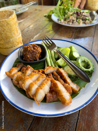 Grilled Thai pork neck served with chili paste, bitter melon, beans and cucumber