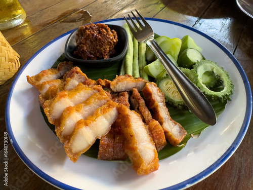 Grilled Thai pork neck served with chili paste, bitter melon, beans and cucumber
