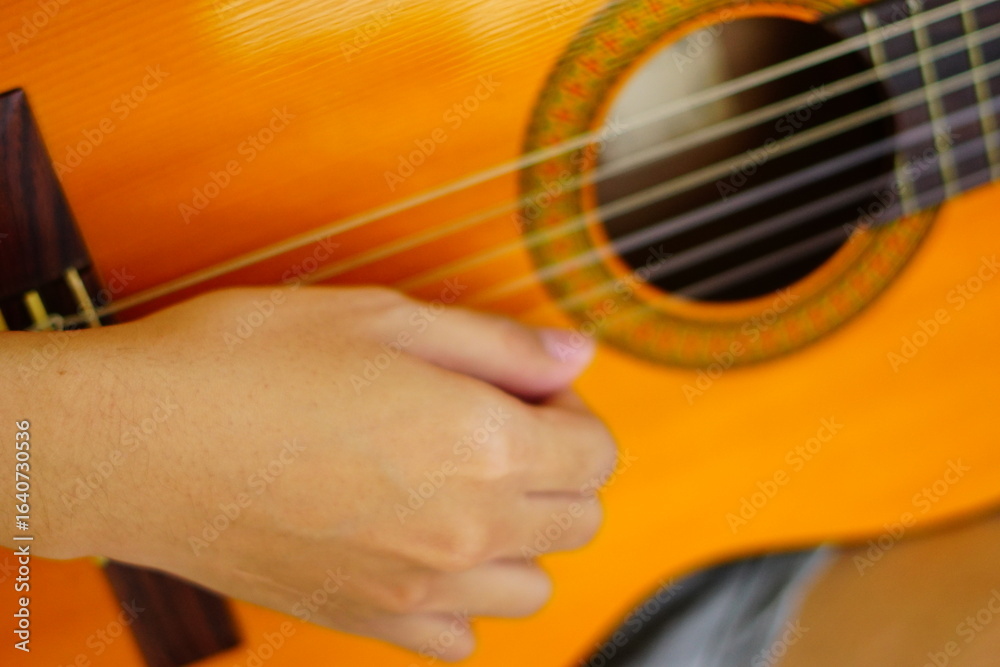 Fototapeta premium close-up shots of hands playing the guitar, showcasing different finger positions and techniques, perfect for music enthusiasts and instructional content