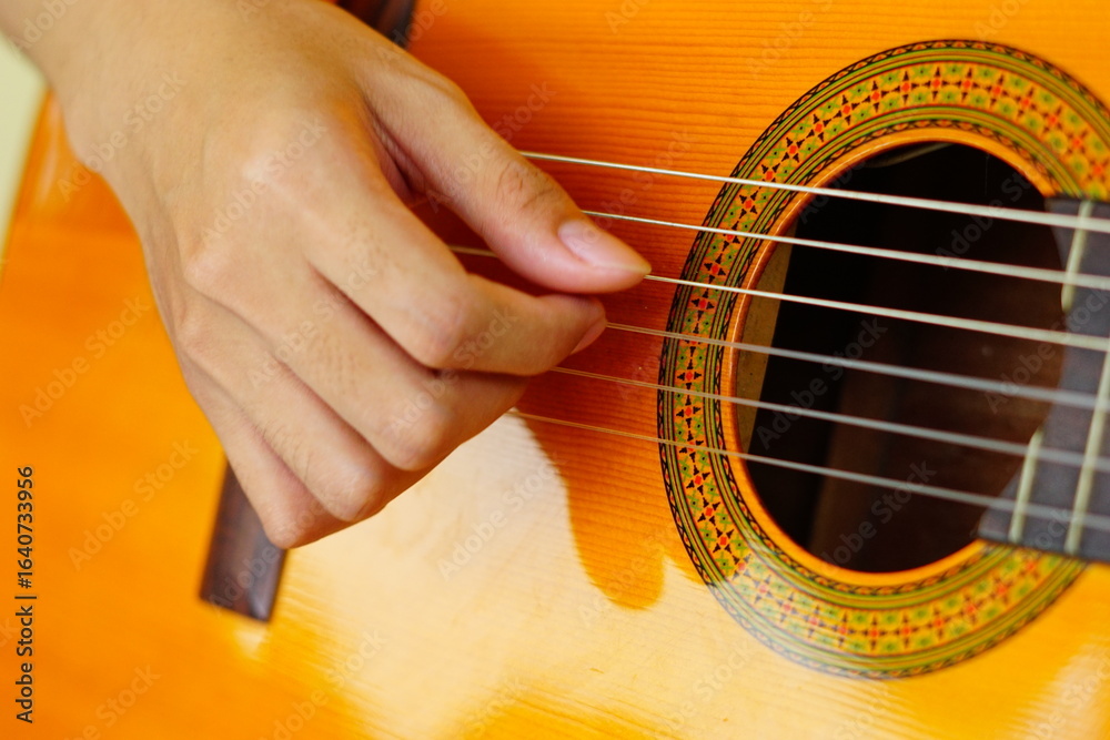 Fototapeta premium close-up shots of hands playing the guitar, showcasing different finger positions and techniques, perfect for music enthusiasts and instructional content