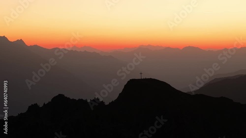 Drone video flying over to the Italian Alps, capturing sunrise, mountain peaks, soft morning light, and peaceful alpine scenery.