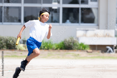 中学校の体育祭でリレーを走る男子生徒