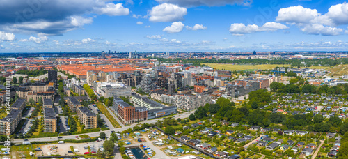 Aerial view of Copenhagen, Denmark, showing red roofed buildings, modern structures, green spaces, residential areas, and a waste to energy plant.