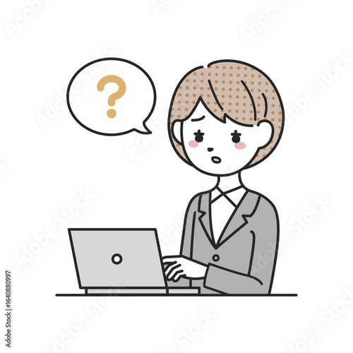 パソコンの前で考えるスーツを着た女性