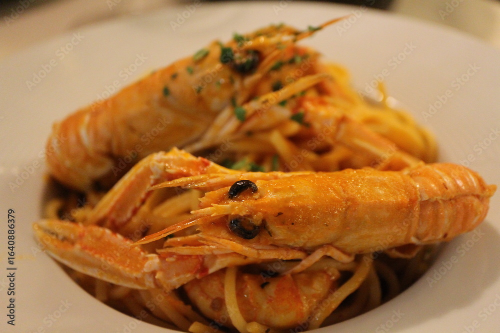 Italian cuisine: spaghetti alla busara (spaghetti with scampi and tomato sauce) in Venice, Italy Italian cuisine: spaghetti alla busara (spaghetti with scampi and tomato sauce) in Venice, Italy