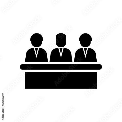 A monochrome icon of three figures seated behind a desk or counter representing an authority panel, concept for court session, legal representation and arbitration hearing session