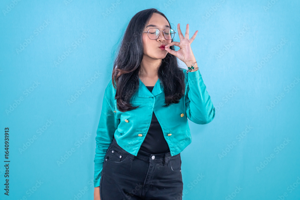 Fototapeta premium Indonesian Asian woman wearing navy dress smiling and giving a sign of pleasure
