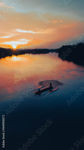 Fishermen's silhouettes paddle across peaceful morning waters.