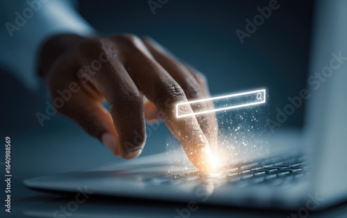A hand hovers over a laptop keyboard, with a glowing search bar appearing