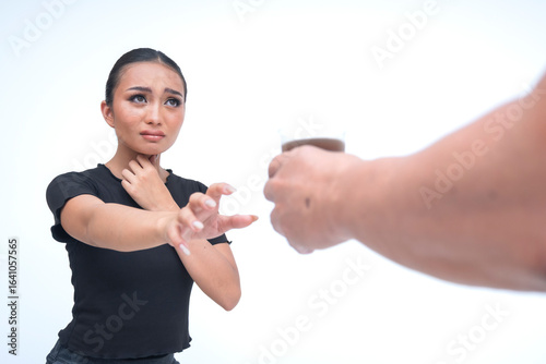 Obraz na plátně A helpless young asian woman holding her throat and reaching out for water, with a thirsty and pleading expression