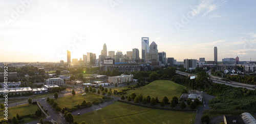 Charlotte, United States - 30 July 2025: Aerial view of a skyline punctuated by the iconic Bank of America Corporate Center and the lush green spaces below.