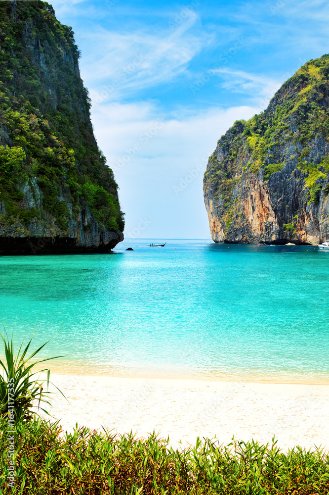 Obraz premium KOH PHI PHI, THAILAND - MARCH 11 2022: Motor boats on turquoise water of Maya Bay lagoon on MARCH 11, 2022 in Koh Phi Phi island, Thailand. This was extremely quiet due to the Covid 19 pandemic.