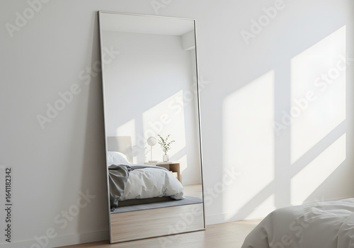 Full length mirror leaning against white wall in bedroom
