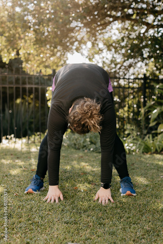Overweight woman in black exercise clothes stretching