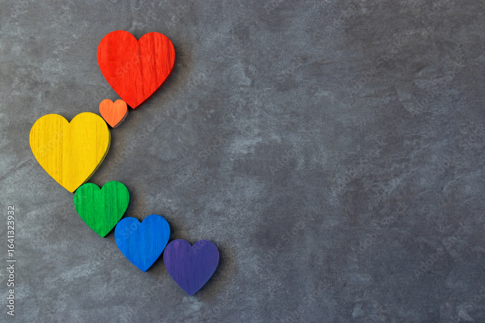 Fototapeta premium Rainbow hearts on the black background. The sing of Lgbt flag.