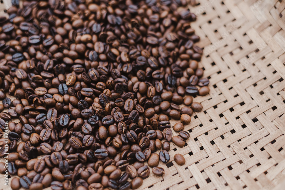 Fototapeta premium Roasted Arabica Coffee Beans Drying on Traditional Woven Bamboo Tray for Artisanal Quality