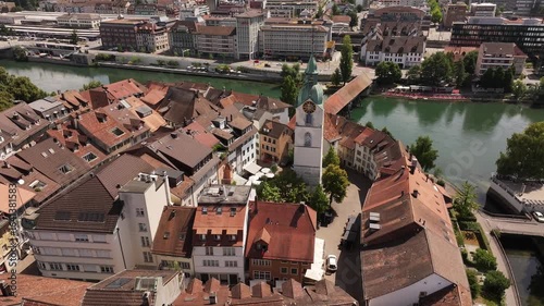 aerial - red tiled roofs circle clocktower and wooden bridge in olten solothurn switzerland