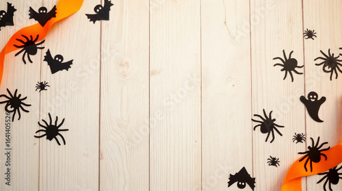 Halloween confetti in bat, spider, and ghost shapes on wood table  