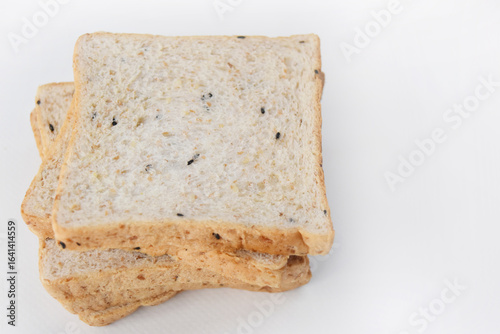 Several slices of fine grain bread stacked on a white background, high angle view showing the bread surface and space on the sides for text.